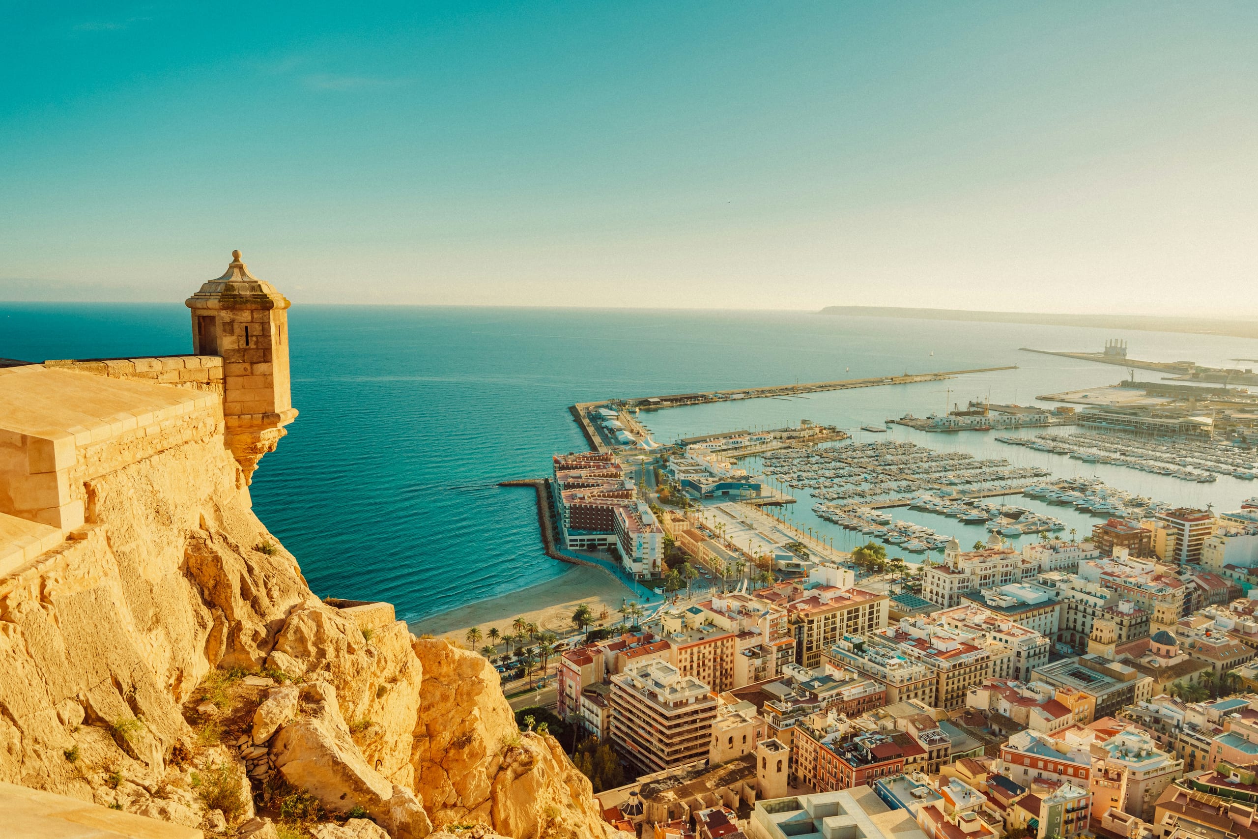 Vista panorámica de Alicante con el Castillo de Santa Bárbara sobre el monte Benacantil, la playa del Postiguet y el puerto deportivo